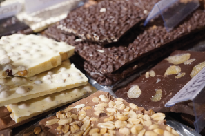 Verschiedene Schokoladentafeln mit Nüssen und anderen Zutaten auf einem Markt.